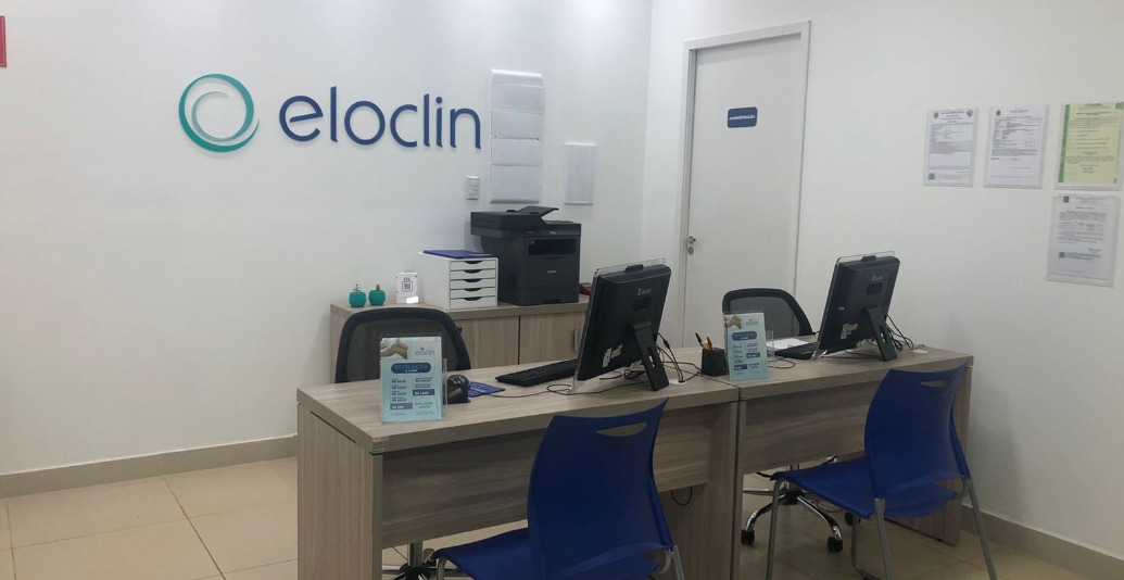 Recepção da Eloclin com balcões de atendimento e identidade visual da clínica