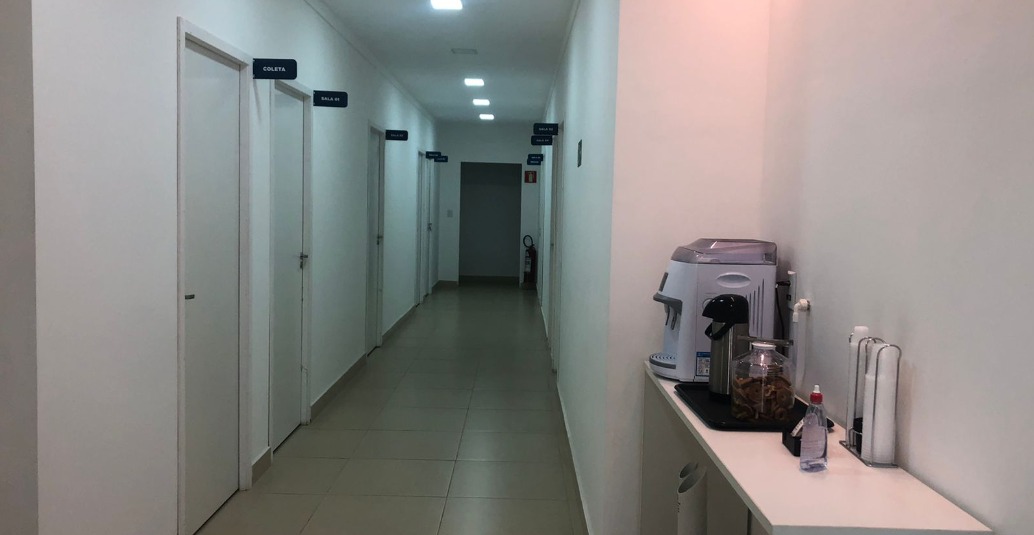 Corredor interno da Eloclin com salas identificadas e área de café